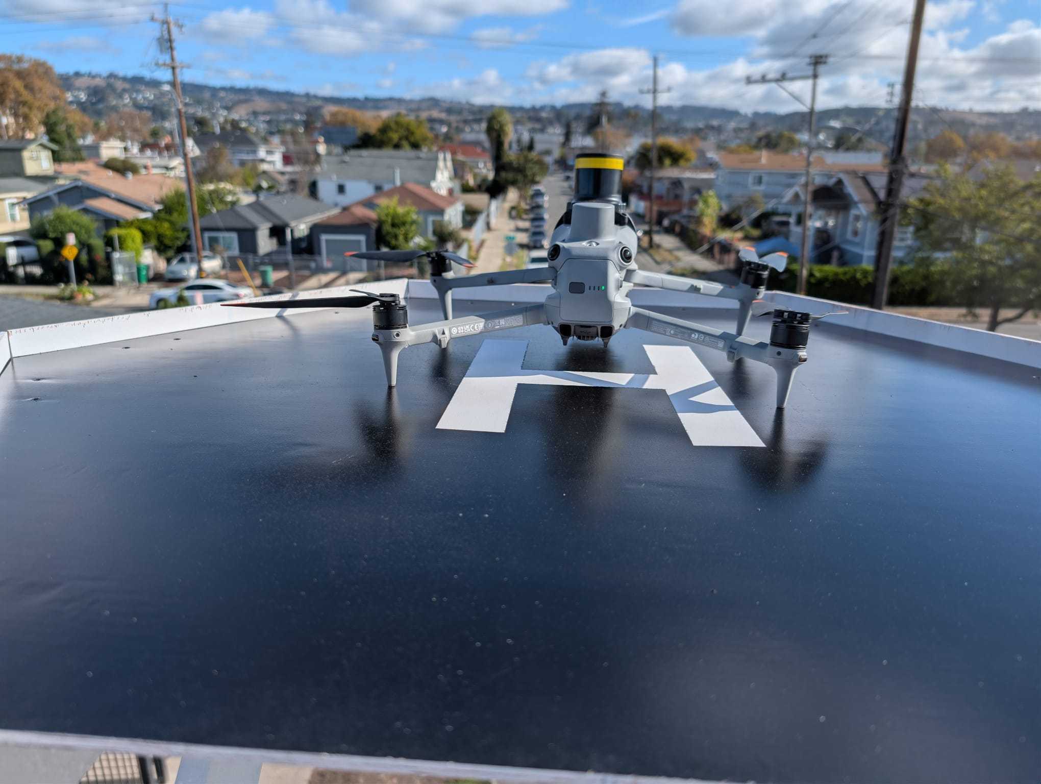 Aerbits drone on its launchpad atop an elevated bucket-van lift overlooking a neighborhood